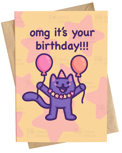 A greeting card with a kraft envelope behind it, featuring a purple cartoon cat holding pink and orange balloons with the text 'omg it's your birthday!!!' on a pale yellow background with pink star shapes.