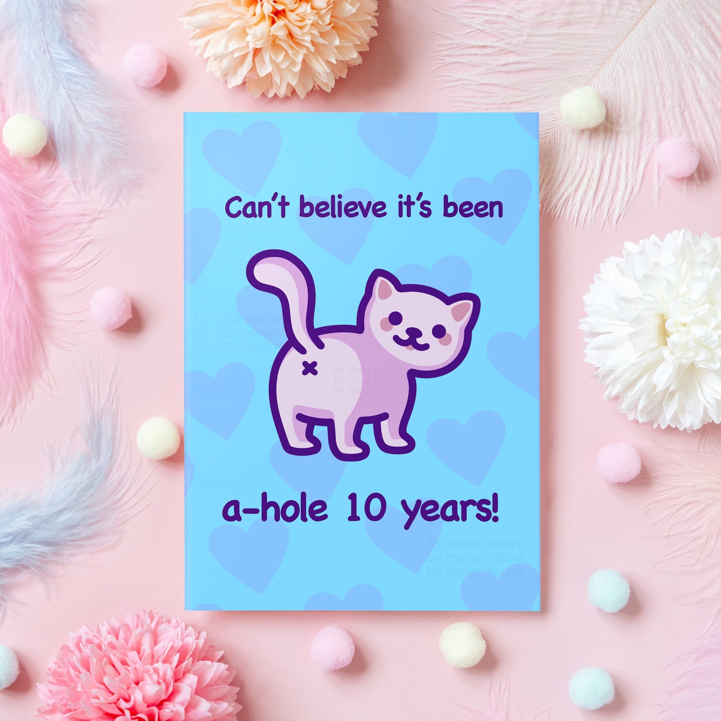 10 year anniversary greeting card with a funny illustration of a white cat with his butt facing the viewer. The card reads: "Can't believe it's been a-hole 10 years!"